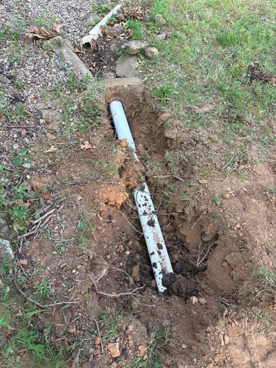 Sewer pipe installation in a narrow backyard trench in Richards, MO
